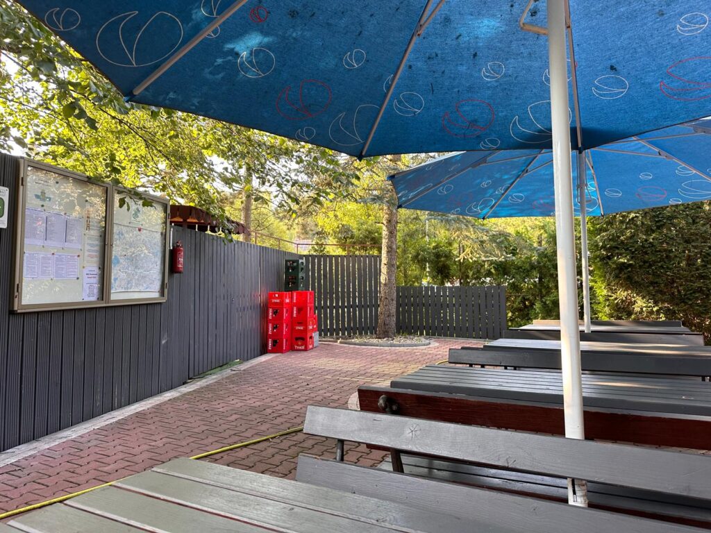 parasoli i laweczki przed recepcja kempingu smok